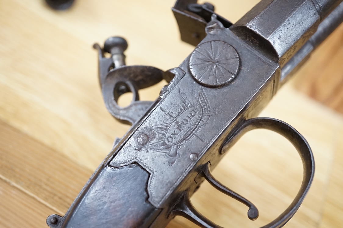 A double barrel flintlock, tap action pocket pistol by Collis of Oxford, with sliding top thumb safety, slab walnut grip, and tower private proof marks